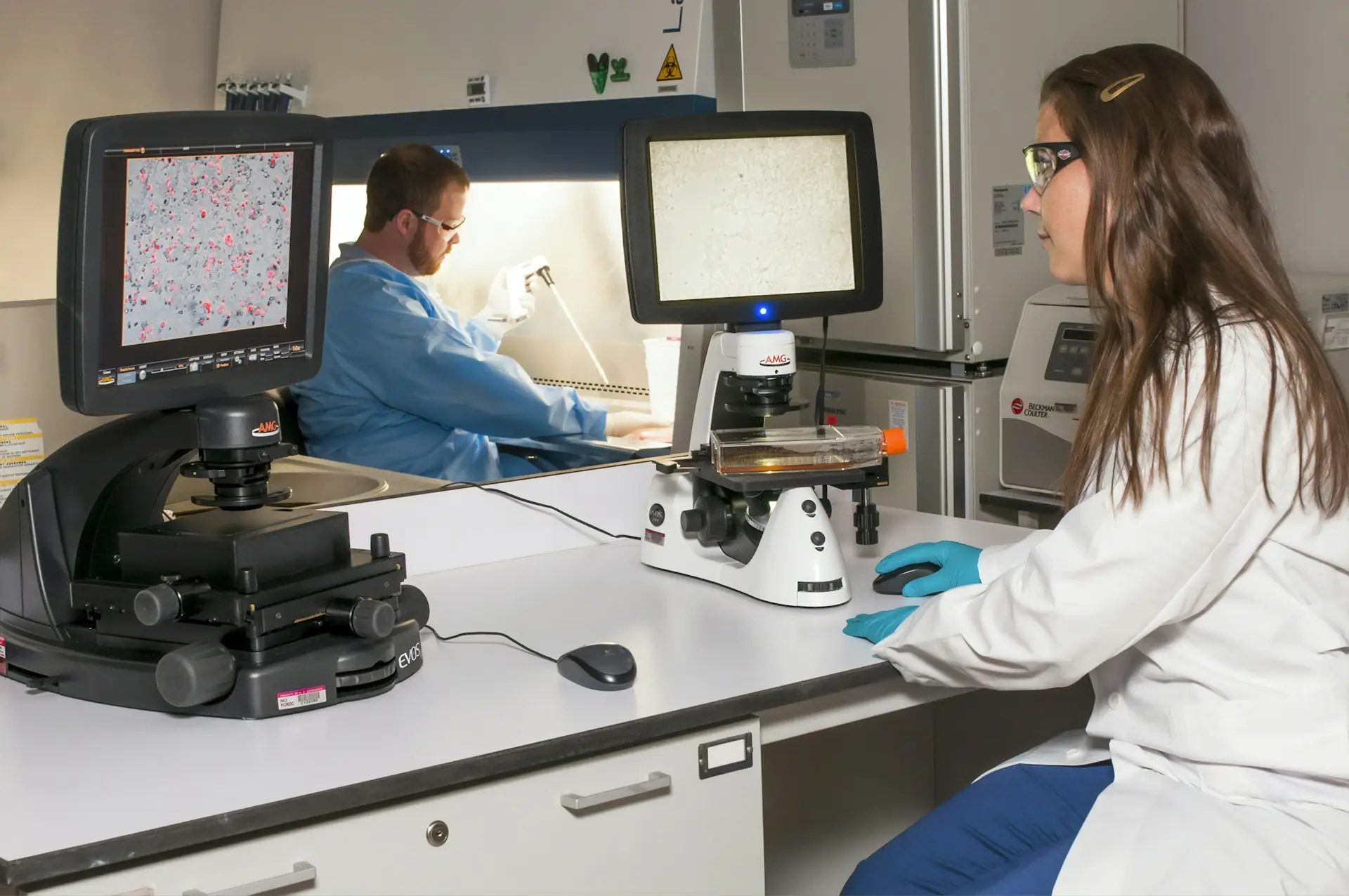 Tecnici al lavoro in laboratorio con microscopi e strumenti digitali